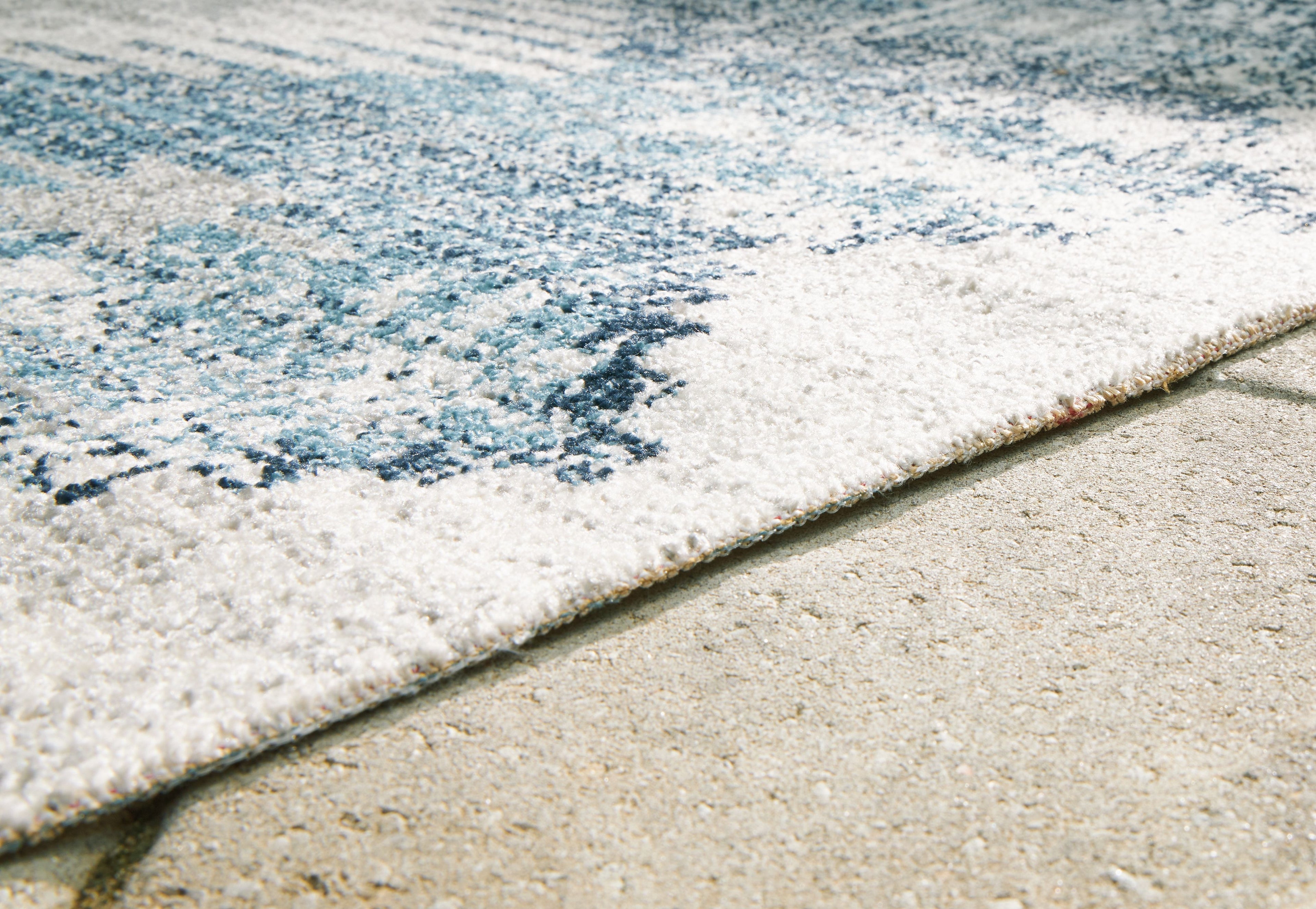 Blue and ivory area rug corner closeup with textured short pile