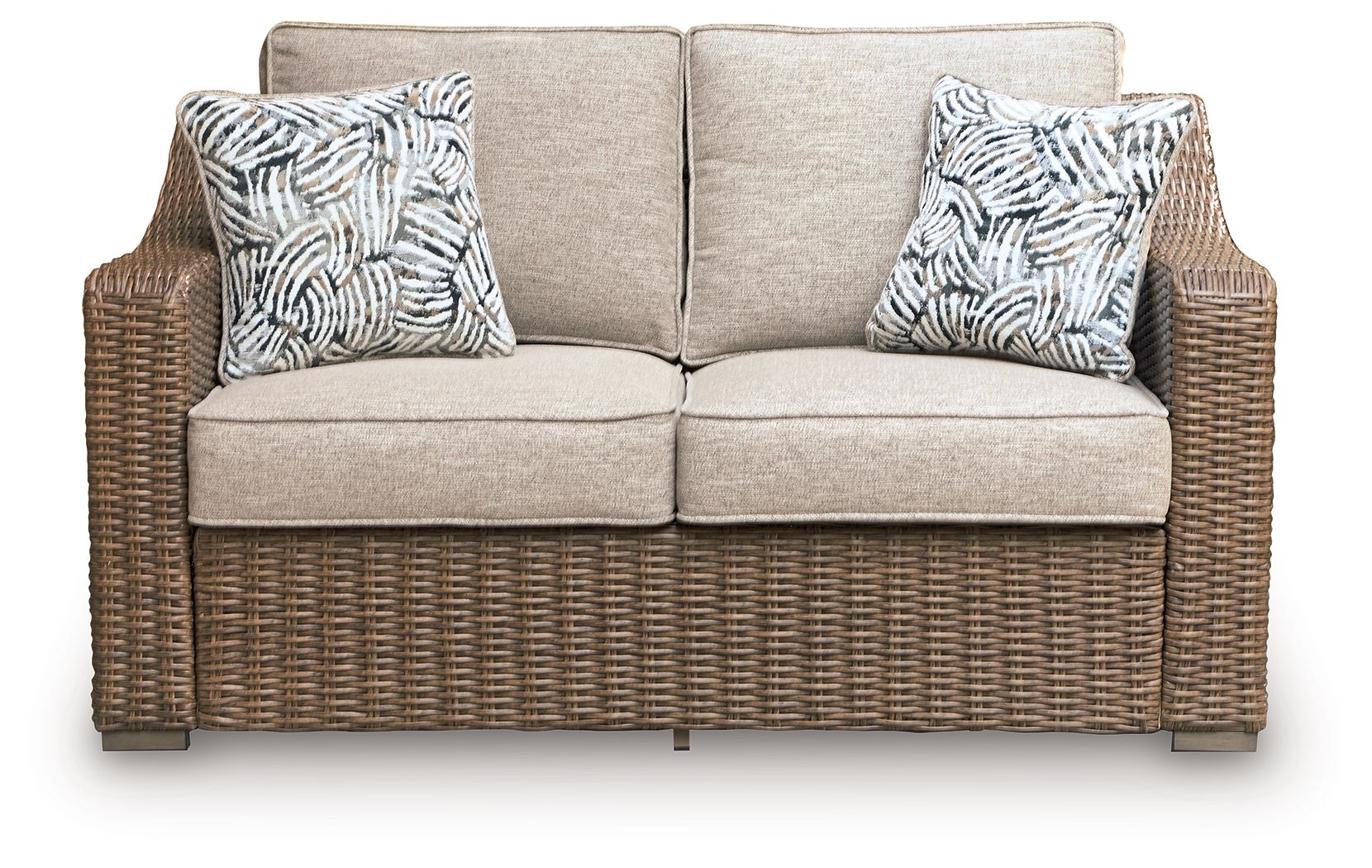 Beige loveseat with two patterned throw pillows and brown woven wicker base