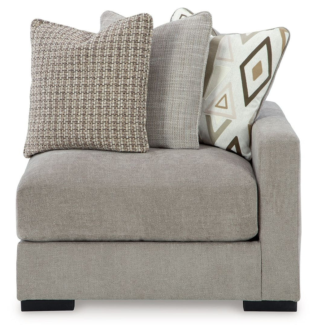 Light gray fabric corner chair with two-tone back cushions and patterned accent pillow