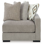 Light gray fabric corner chair with two-tone back cushions and patterned accent pillow