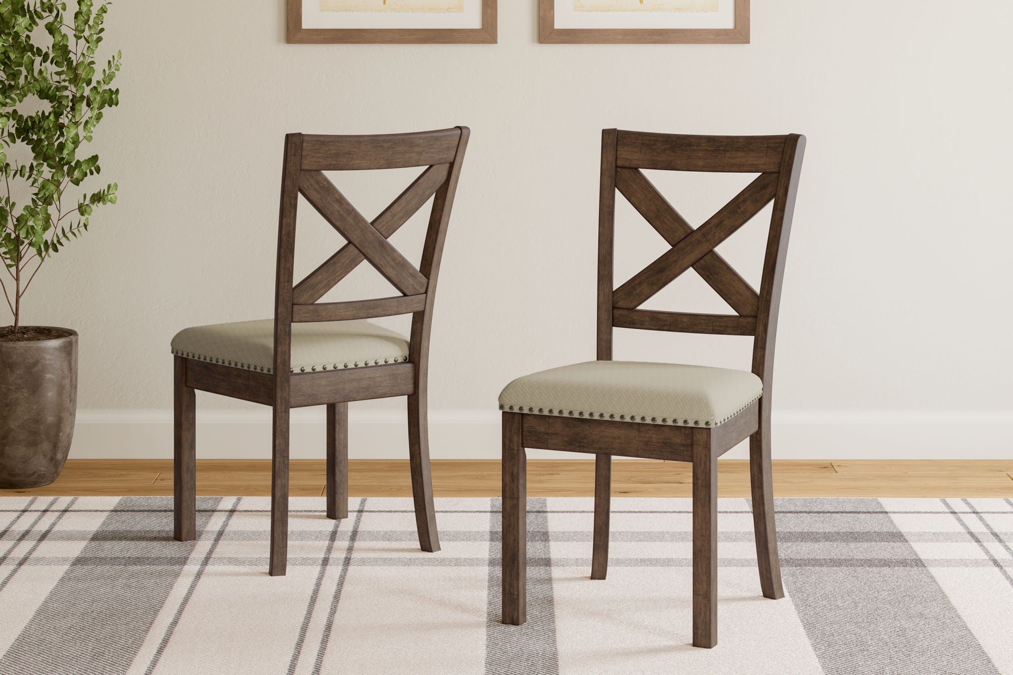 Pair of padded dining side chairs with beige seats and X-back wood frames.