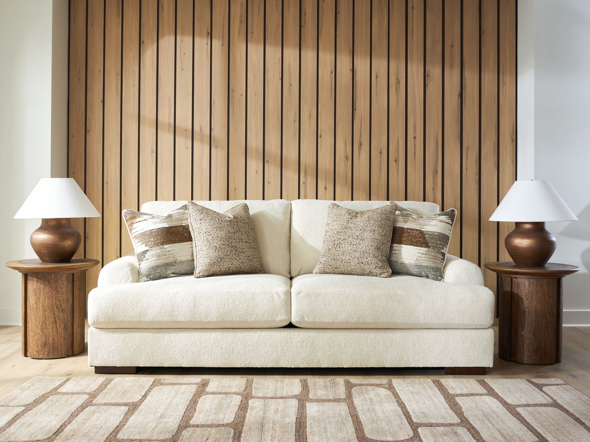 Light beige fabric sofa with three seat cushions and four back pillows