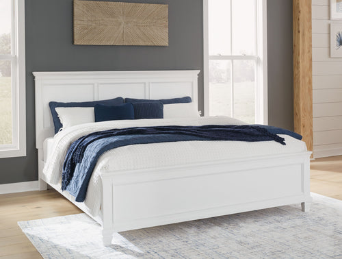 White panel bed frame with paneled headboard and low rails, styled with bedding