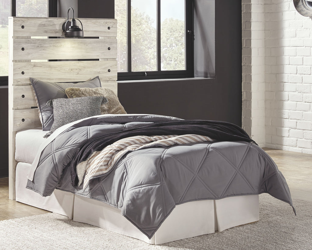 Beige panel headboard with black lamp on top, over a white upholstered bed