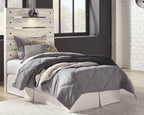 Beige panel headboard with black lamp on top, over a white upholstered bed