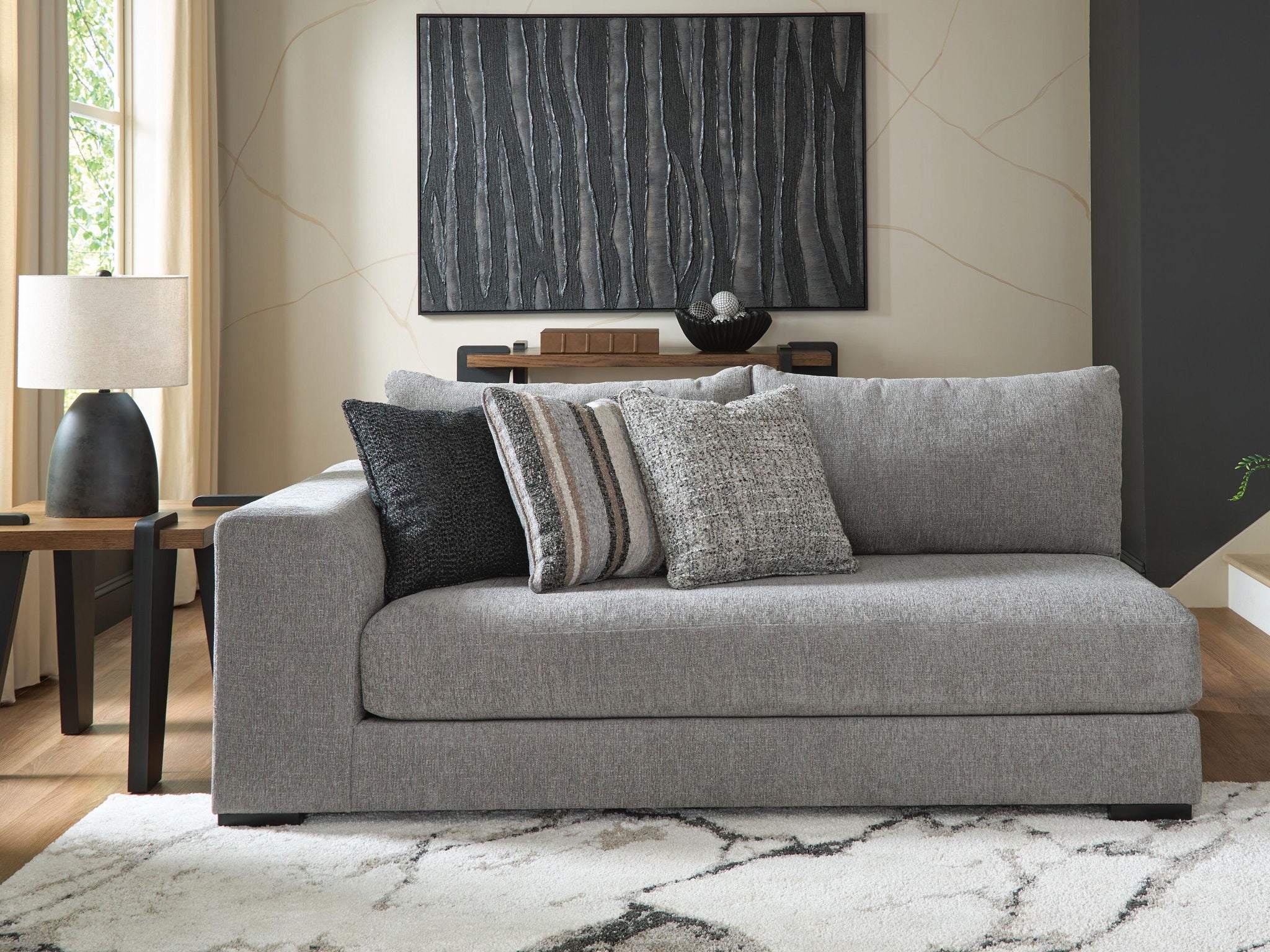 Gray fabric corner chaise with striped and solid accent pillows