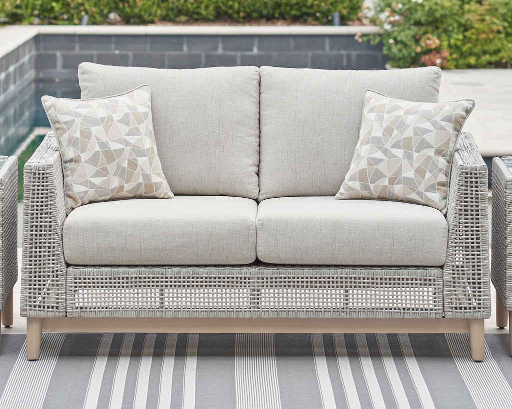 Gray woven loveseat with two seat cushions and three light patterned pillows