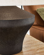 Distressed brown metal lamp base with textured surface and beige drum shade