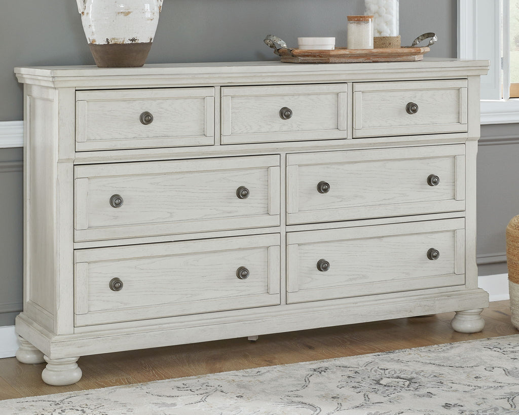 White sleigh-style dresser with nine drawers and bun feet
