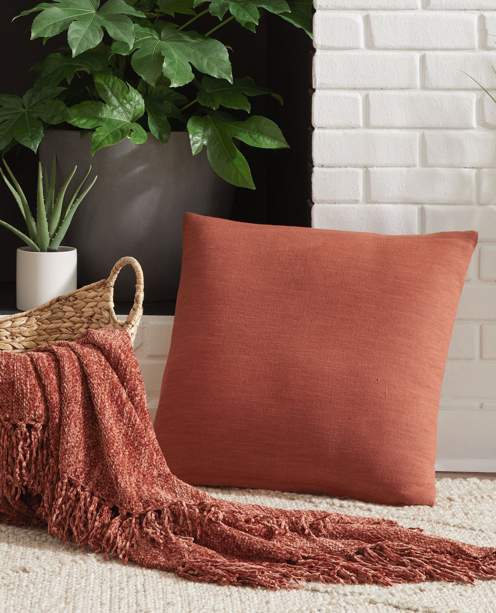 Square throw pillow, coral-red fabric with stitched edge
