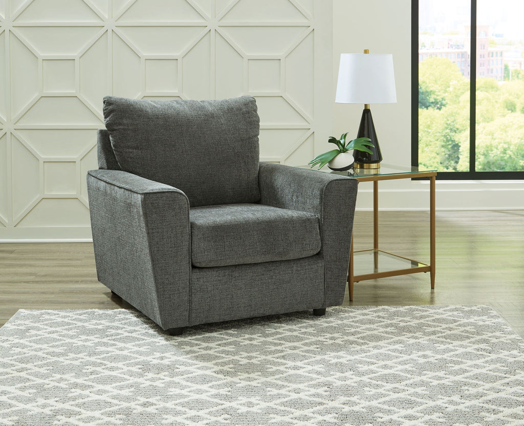 Gray upholstered armchair 3/4 view with cushioned seat and tall backrest