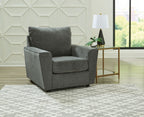 Gray upholstered armchair 3/4 view with cushioned seat and tall backrest