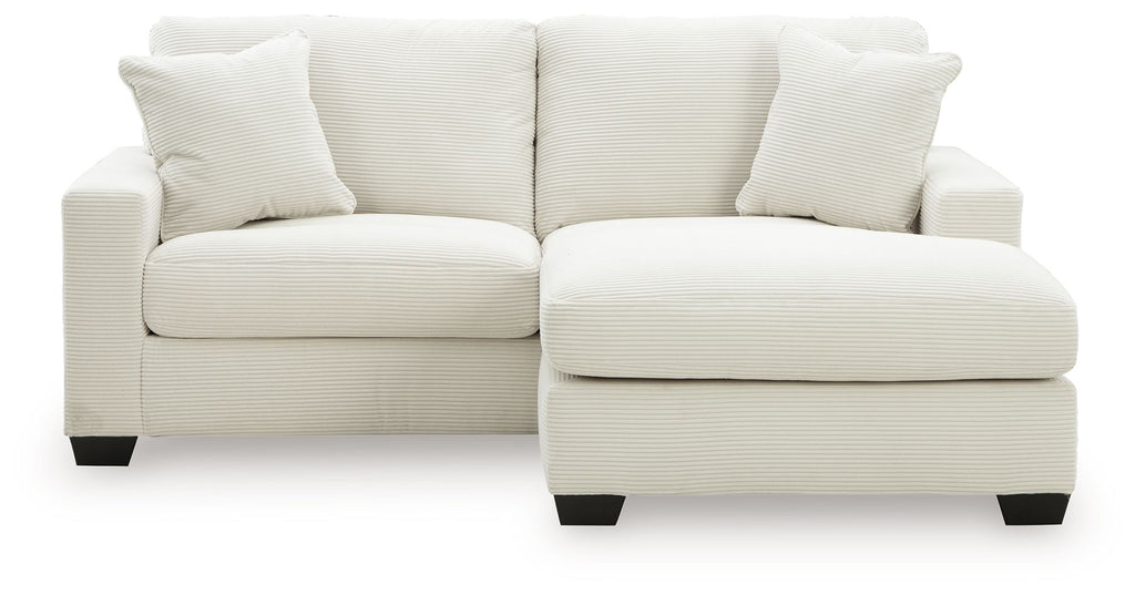 White sofa chaise with two back cushions and a curved chaise ottoman base