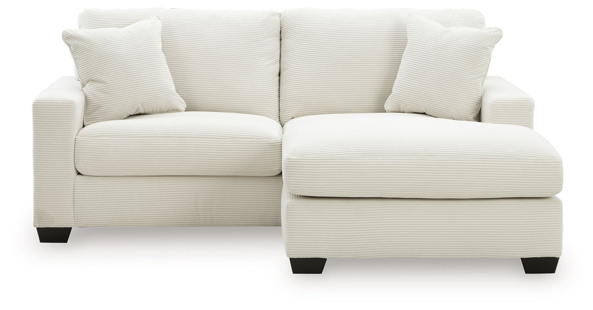 White upholstered sofa with chaise extension and back pillows, square arms