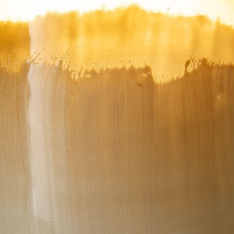 Close-up glaze detail of ombre amber and ivory vase with textured band