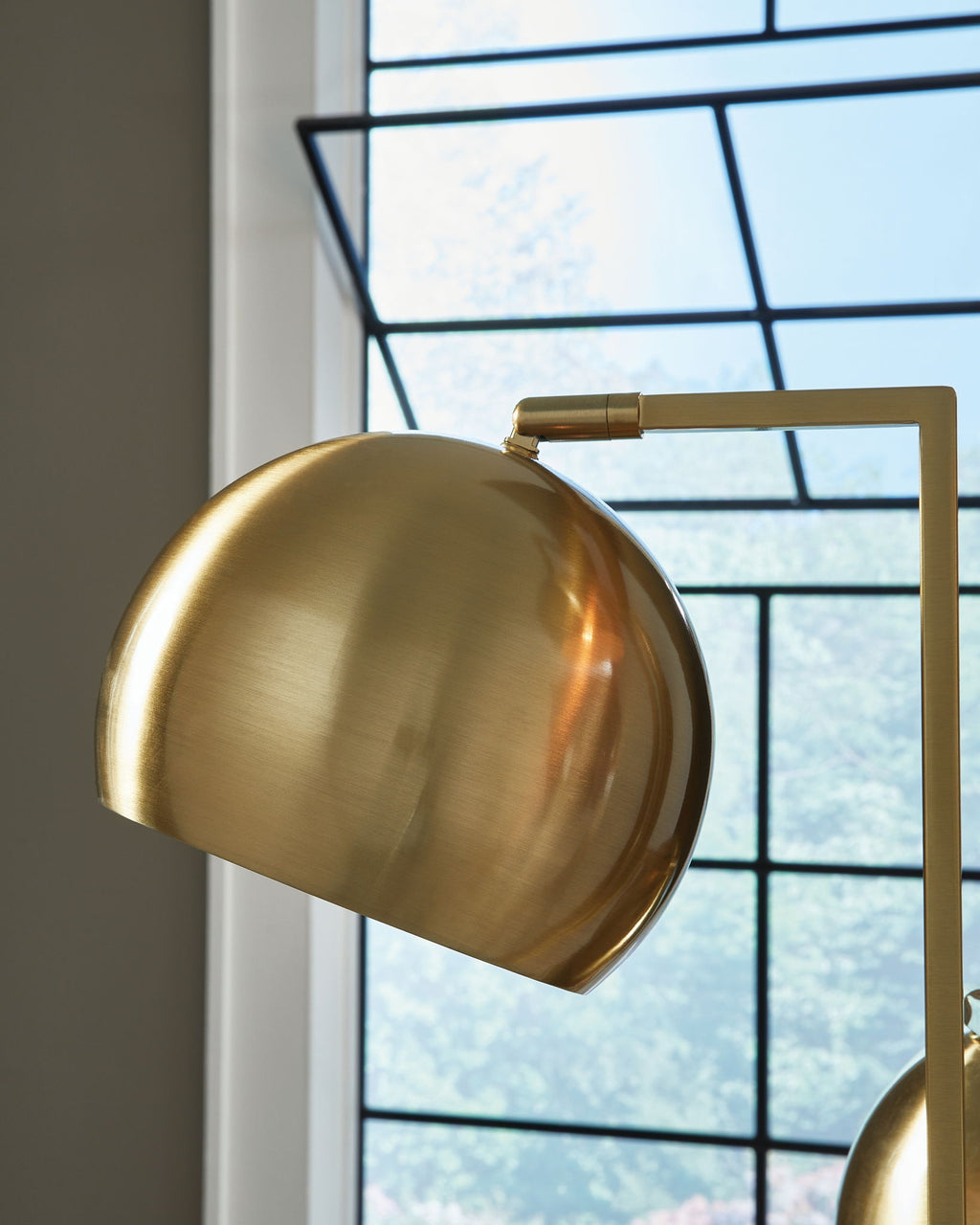 Gold dome-style lamp shade with a visible bulb opening and metal arm