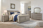 Sleigh bed set in gray finish with upholstered headboard, dresser, and arched mirror
