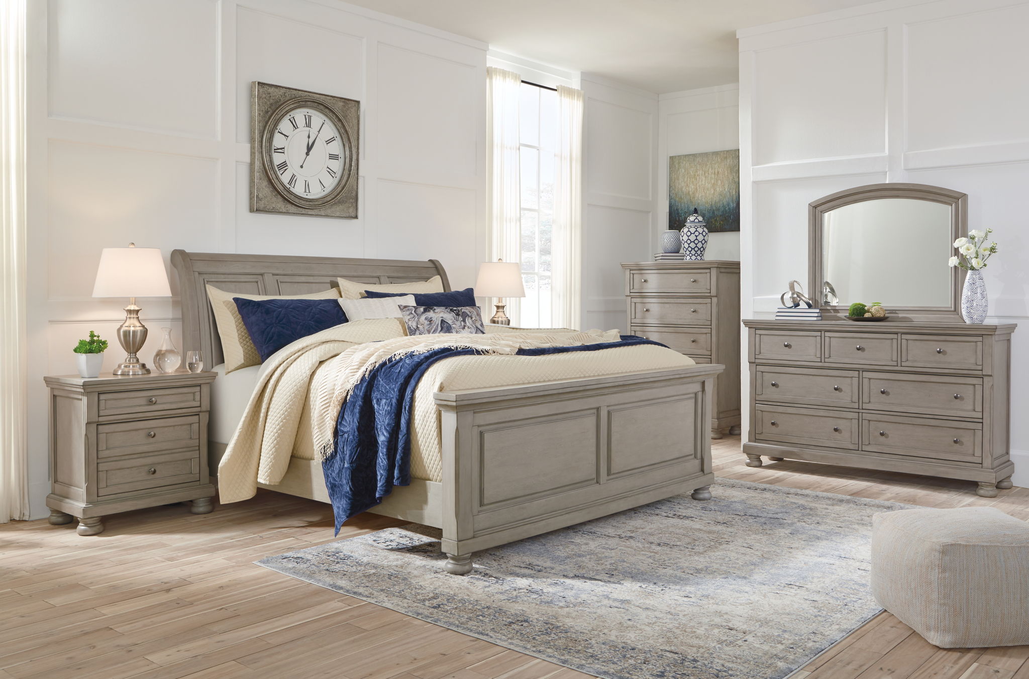 Sleigh bed set in gray finish with upholstered headboard, dresser, and arched mirror