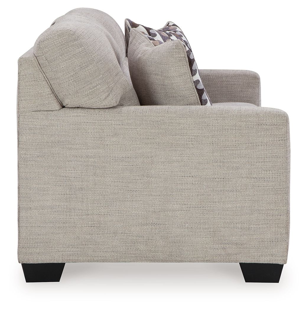 Pebble sofa sleeper side view with a patterned accent pillow and rounded arms