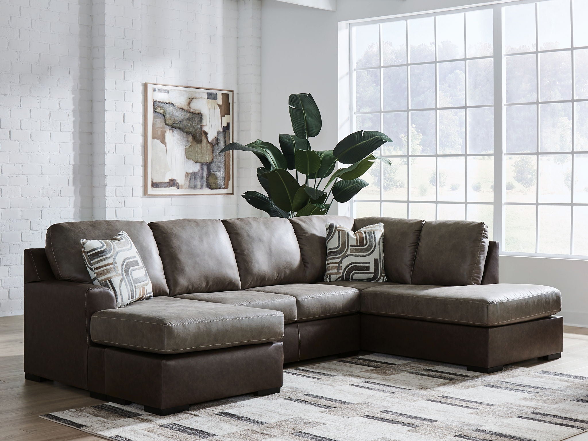 Dark fossil sectional sofa with chaise corner and three gray patterned accent pillows