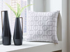 White square pillow with black circular grid pattern on the front face