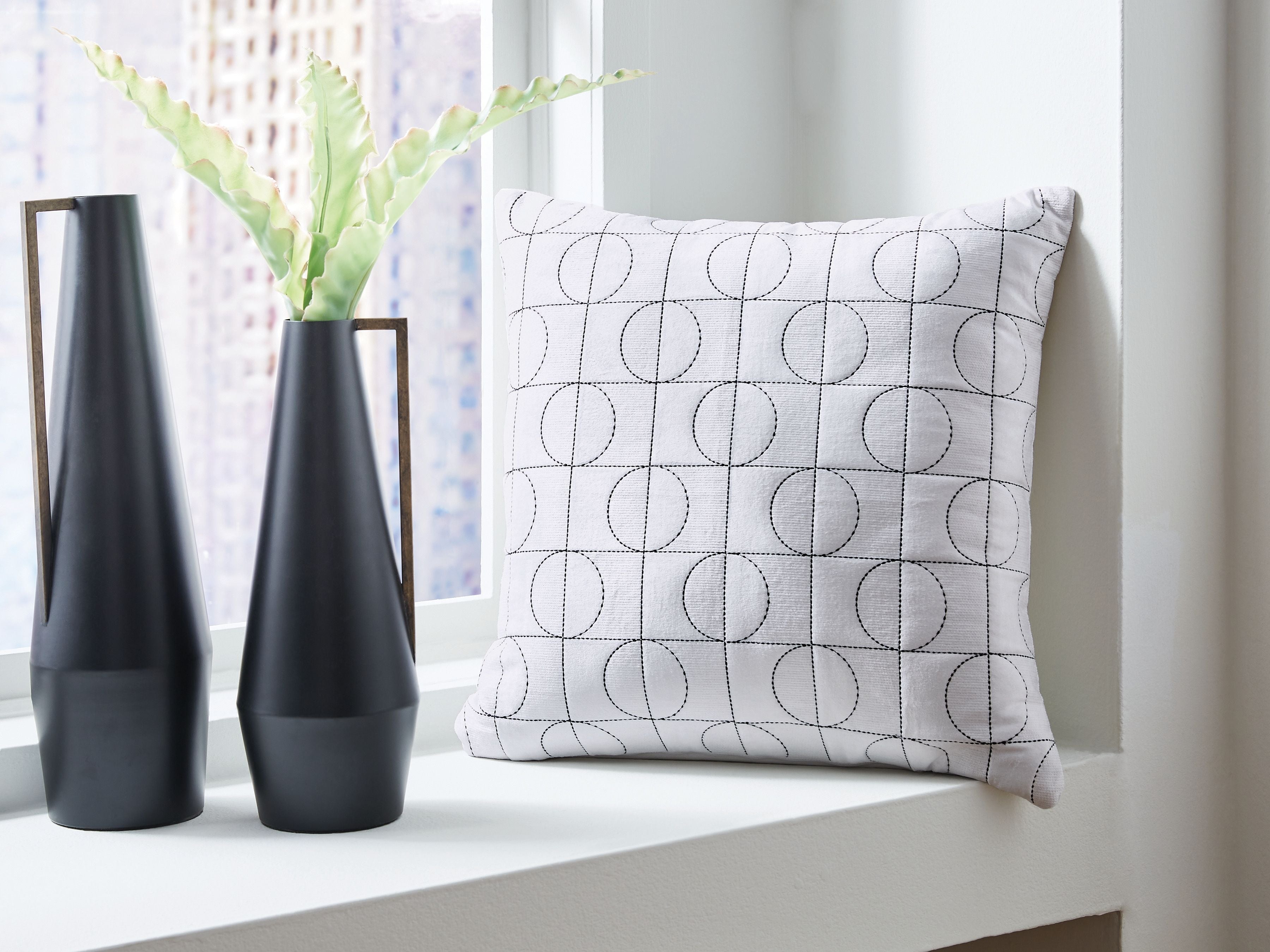 White square pillow with black circular grid pattern on the front face