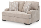 Taupe loveseat with wide track arms, tufted seat cushions, and two gray striped pillows