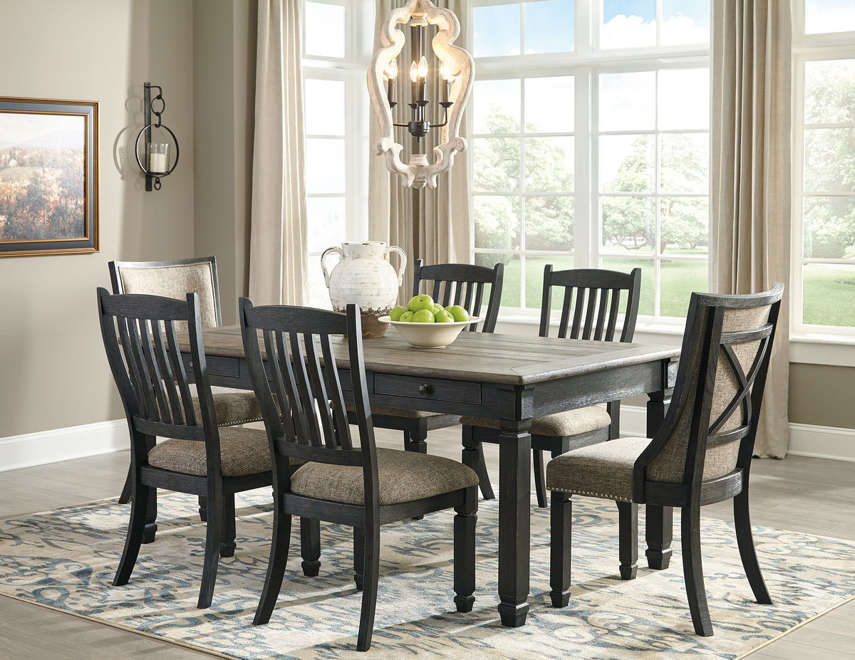 Dark gray dining table with four slat-back chairs and upholstered seat cushions