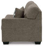 Sofa arm and backrest in dark brown fabric with patterned throw pillow at seat