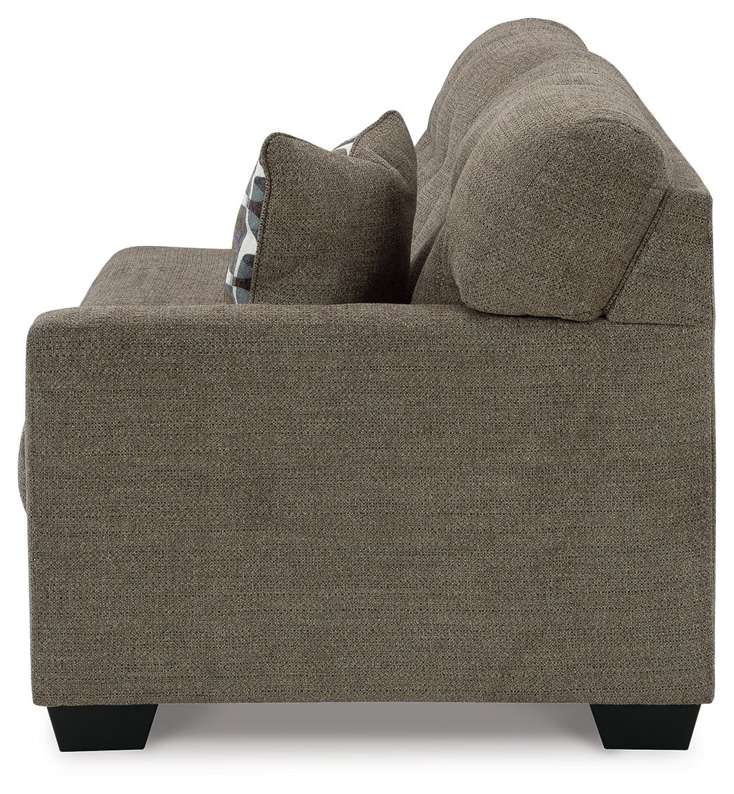 Sofa arm and backrest in dark brown fabric with patterned throw pillow at seat