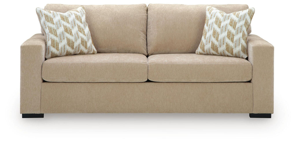 Sofa sleeper front view in light tan fabric with two patterned pillows