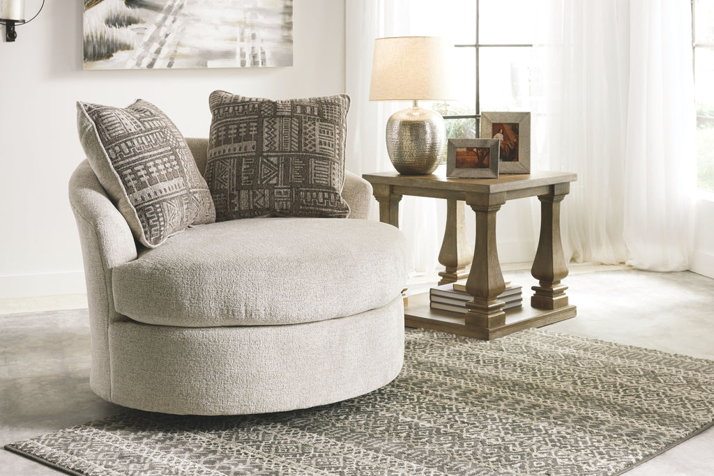 Beige fabric accent chair with patterned throw pillows