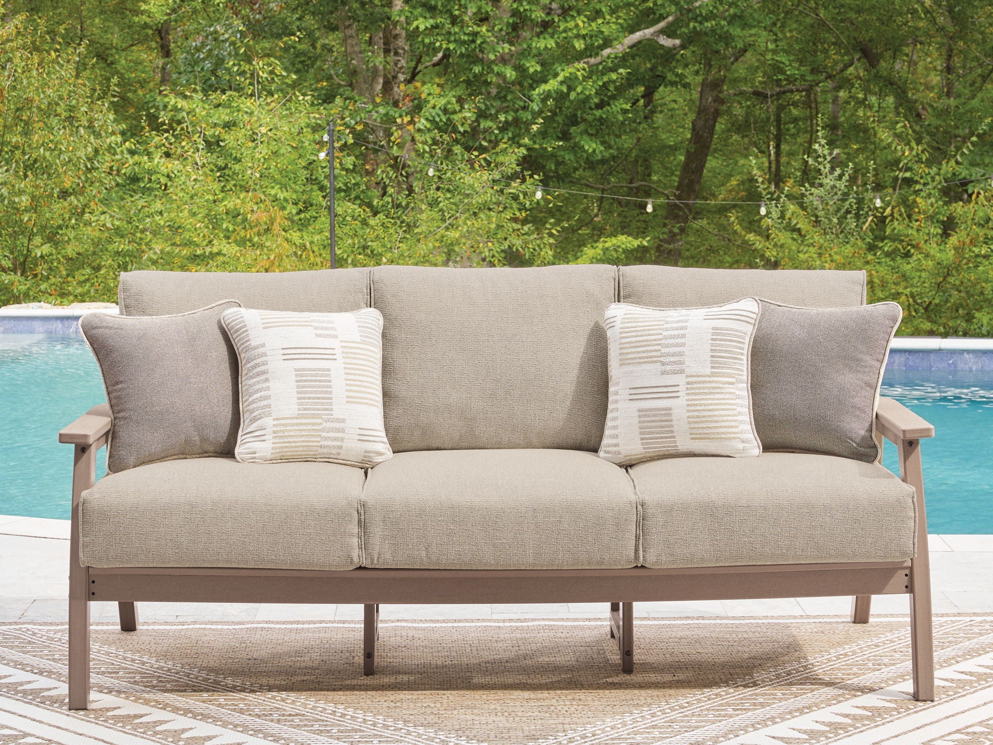 Gray outdoor sofa with two seat cushions and two striped throw pillows