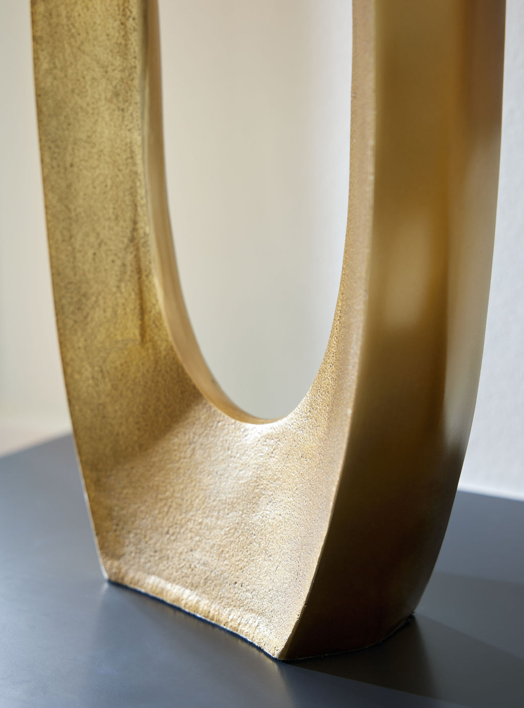 Gold metal vase with tall oval cutout and flared base