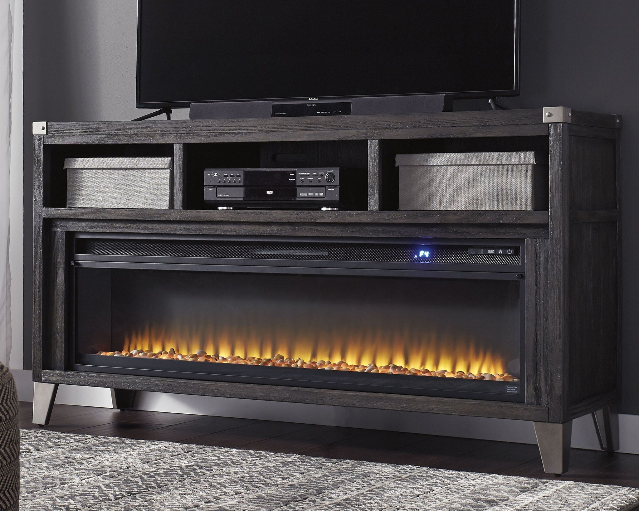 Gray media console with fireplace insert, central electronics shelf, and glowing flames