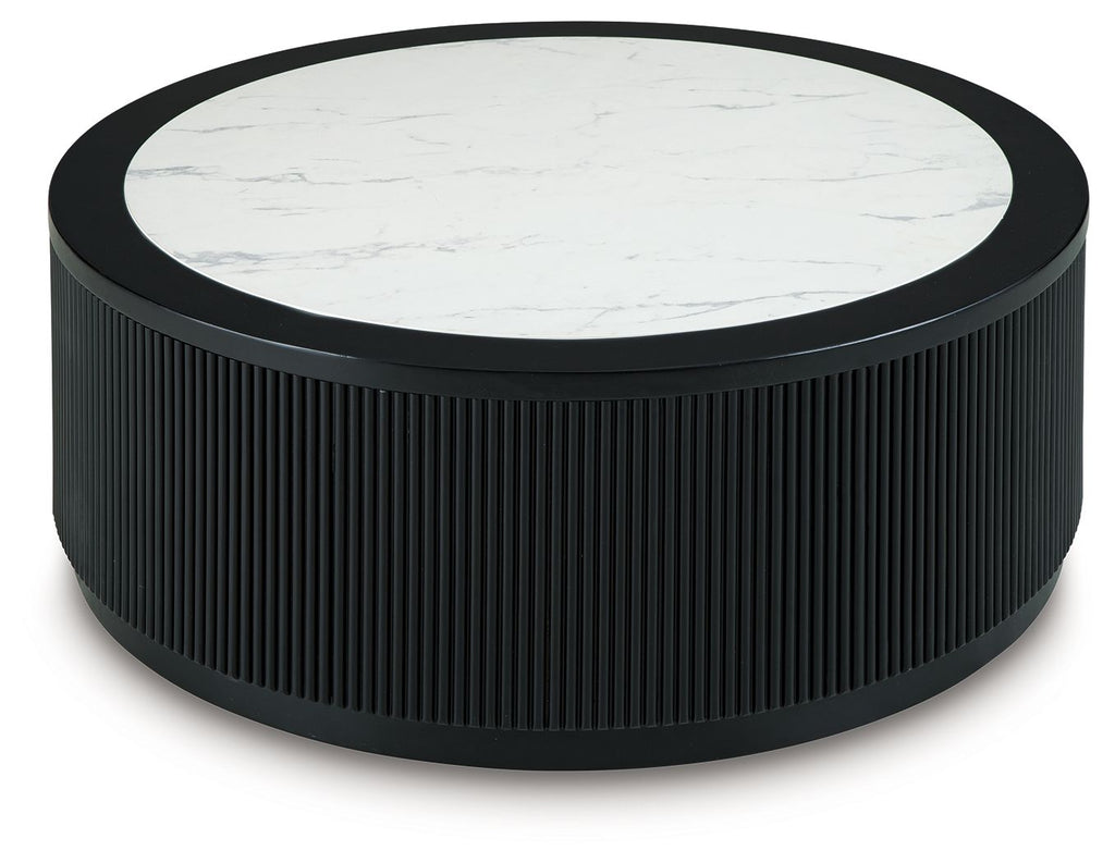 Black ribbed round table with white marble-look top and dark outer rim