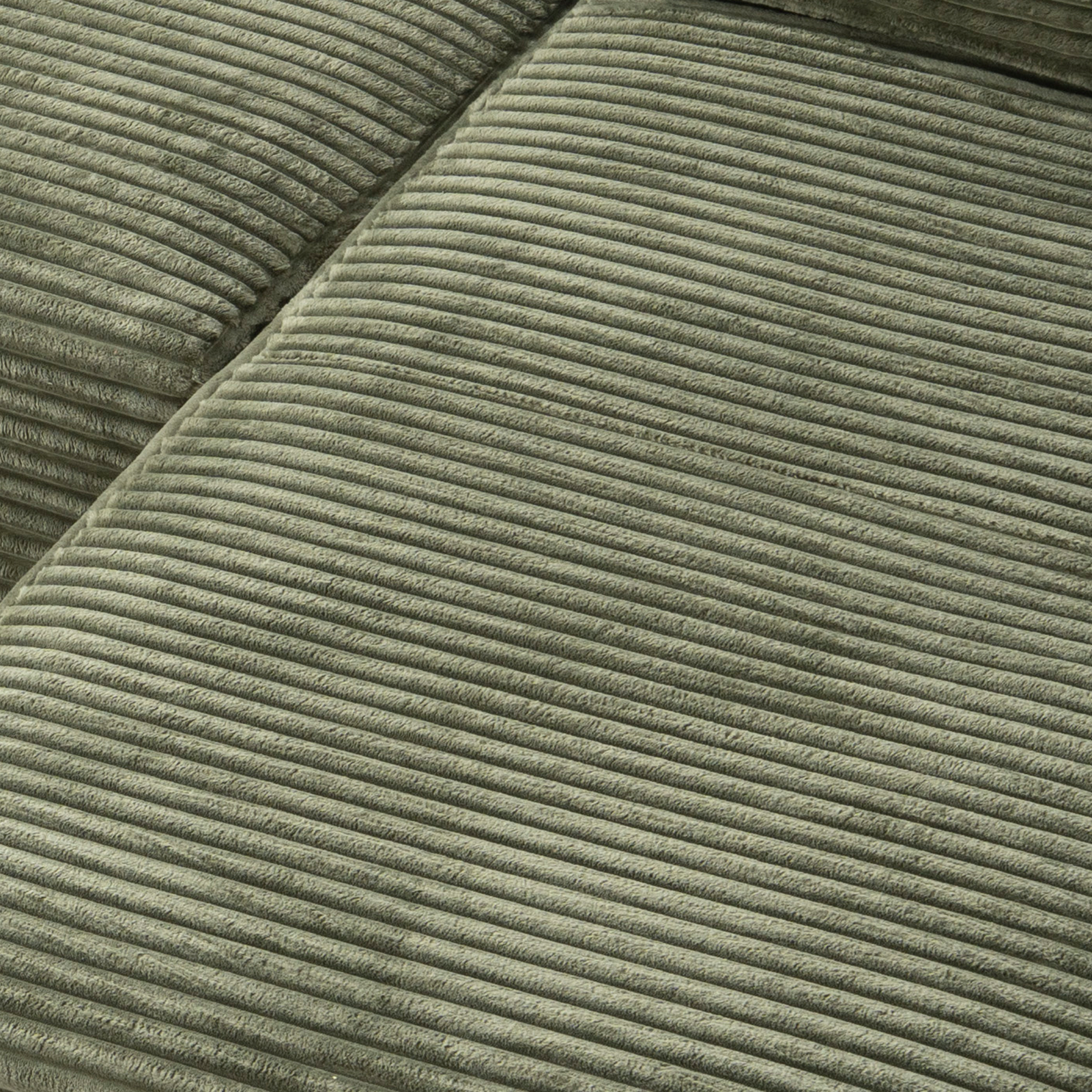 Green corduroy upholstery fabric texture on sectional cushion