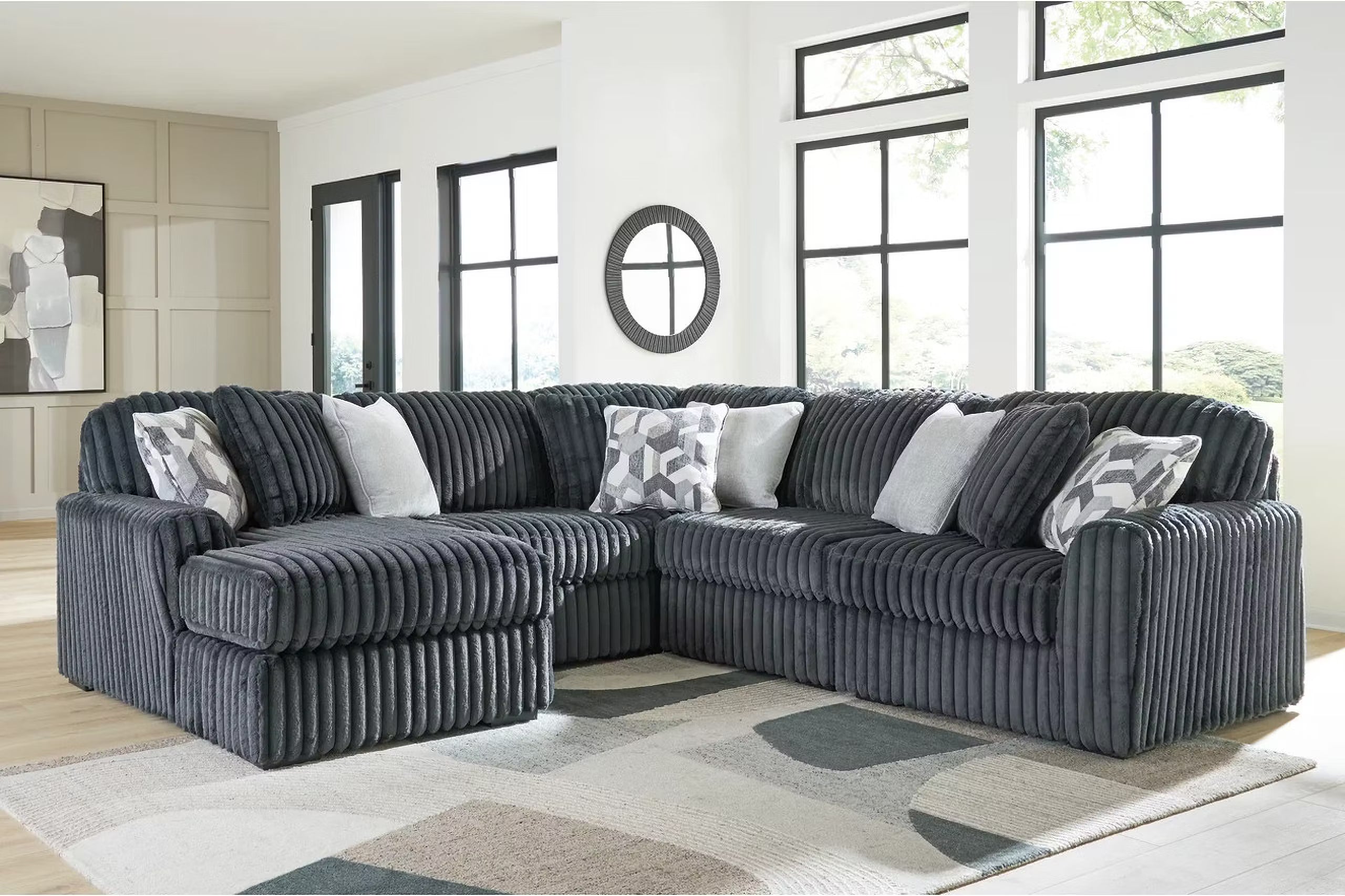 Blue-gray corduroy sectional sofa with corner chaise and patterned accent pillows