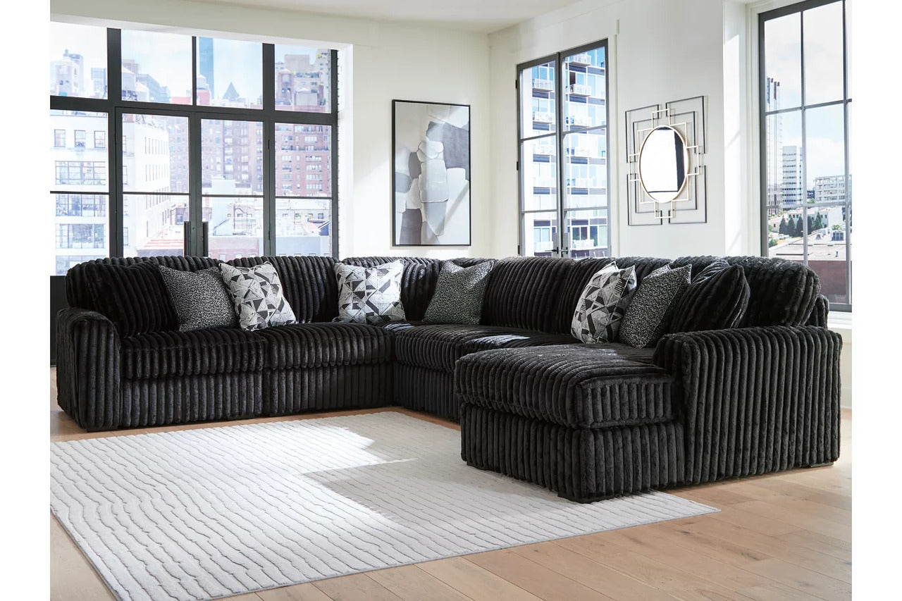 Sectional sofa with chaise, black corded fabric and gray patterned throw pillows