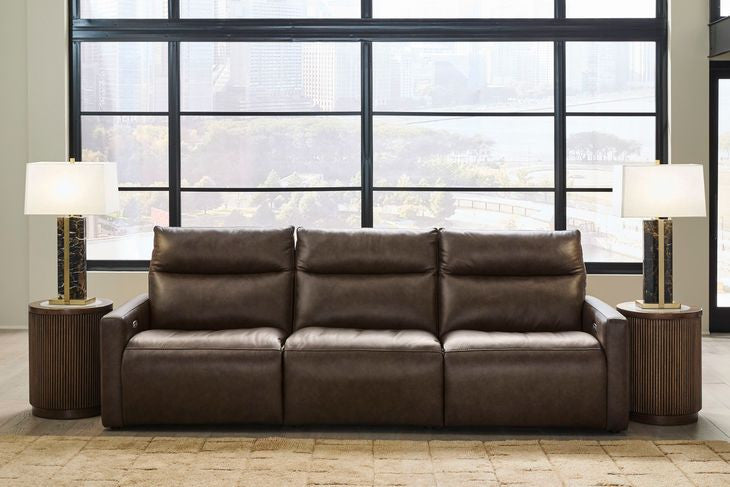 Chocolate power reclining sofa with tufted back cushions and padded armrests
