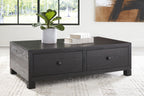 Dark wood cocktail table with two storage drawers and turned feet, rectangular top