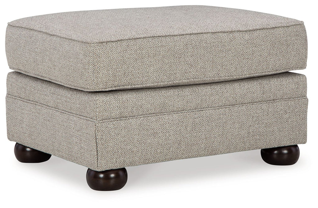 Light beige upholstered ottoman with padded hinged lid and dark wooden legs