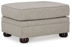 Light beige upholstered ottoman with padded hinged lid and dark wooden legs
