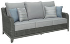 Gray woven outdoor sofa with seat cushions and light blue striped pillows