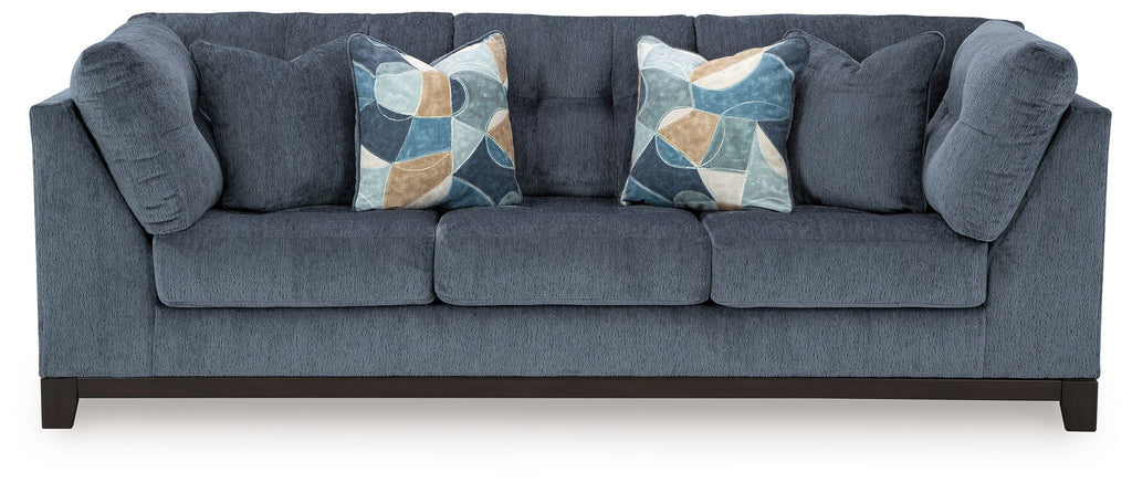 Navy fabric sofa with tufted arms and three decorative geometric throw pillows
