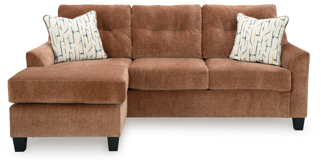 Clay sofa chaise with two square patterned throw pillows and tufted back cushions