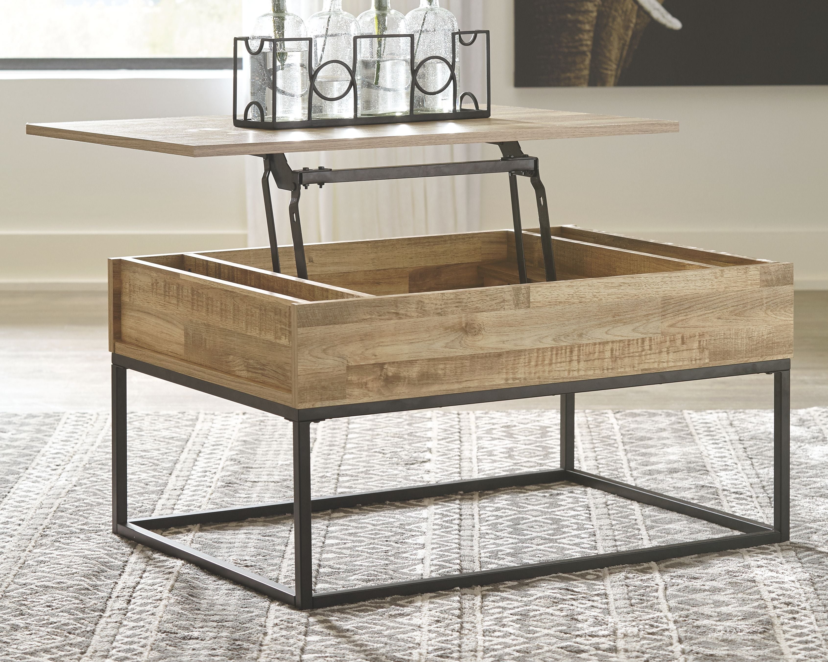 Lift-top cocktail table in light wood with open interior and black metal legs
