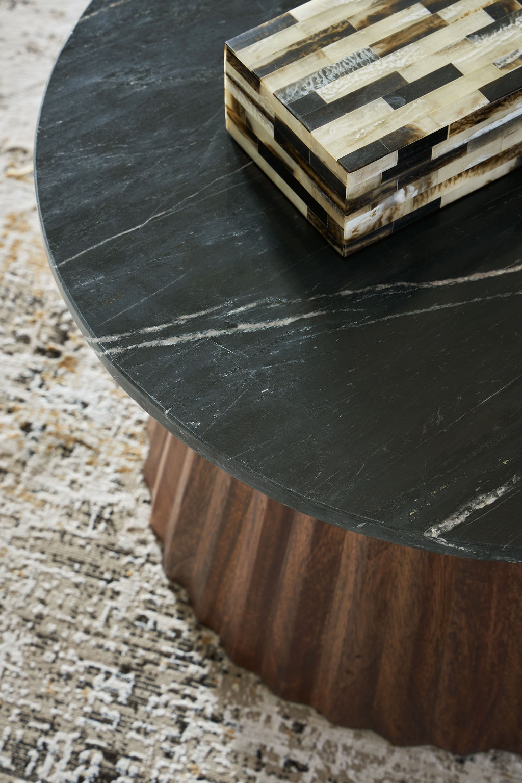 Round black tabletop edge with brown wood base and layered stripe pattern