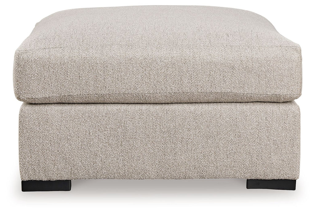 Sand-colored oversized ottoman with padded top and dark block feet