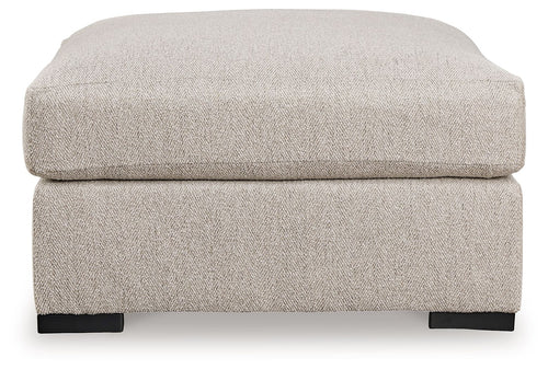 Sand-colored oversized ottoman with padded top and dark block feet